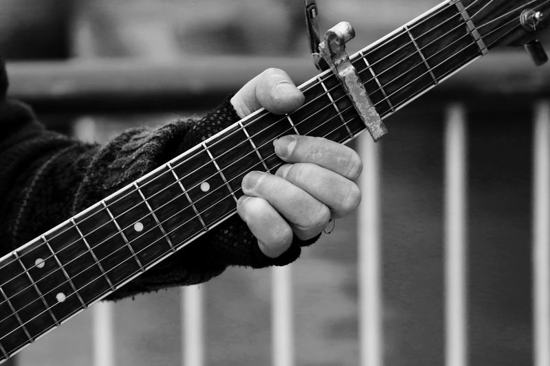 Close-up of cropped hand holding guitar