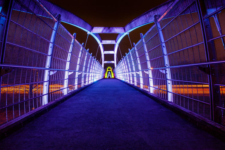 Rear view of man on footbridge at night