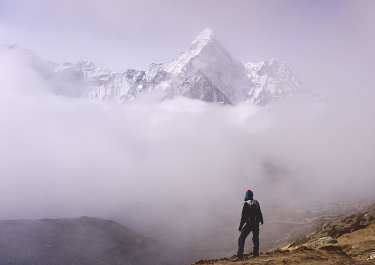 Rear view of woman on snowcapped mountain