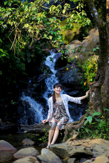 Young woman looking at waterfall in forest