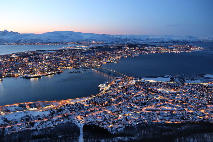 Aerial view of town by sea against clear sky