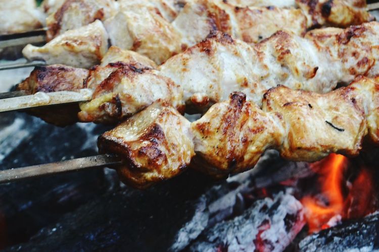 Close-up of meat in skewer on barbecue grill