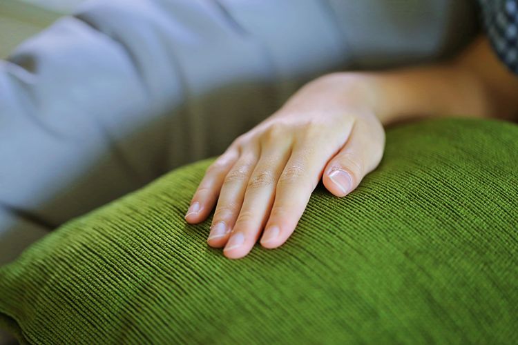 Cropped hand of woman on cushion