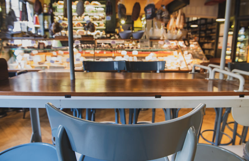 Table and chair in restaurant and food market stall defocused in background
