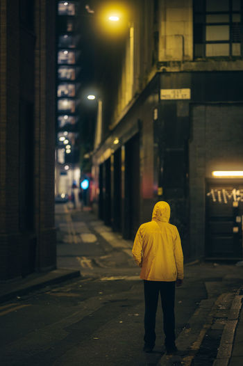 Rear view of man walking in city at night