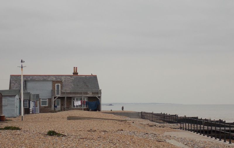House on beach by sea against clear sky