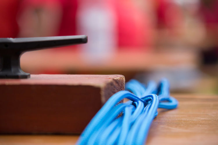 Close-up of blue rope by wooden block on table