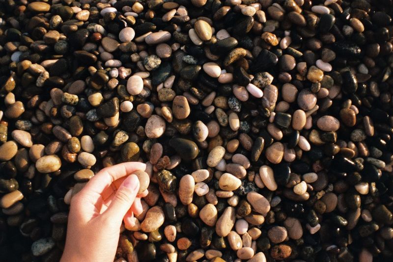 Close-up of hand holding pebbles