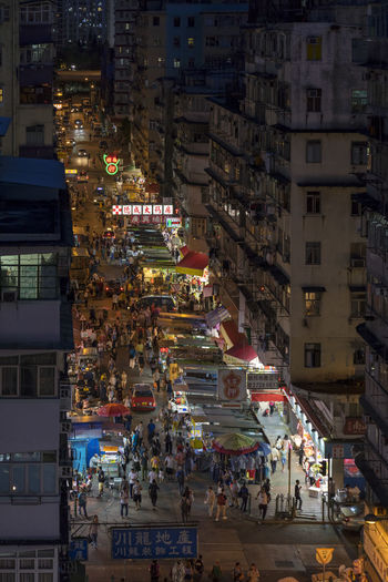 High angle view of crowd on city street by buildings at night
