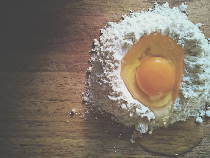 Directly above view of egg and flour on table