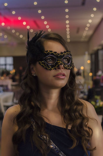 Beautiful woman wearing eye mask during party