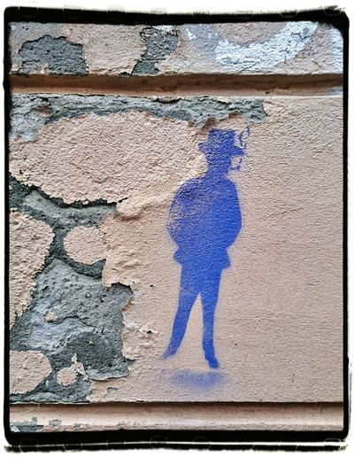 Blue painting of man on weathered wall