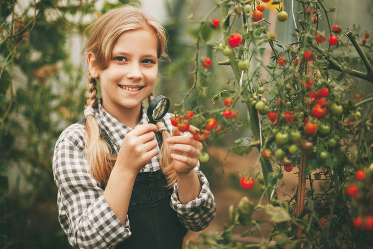 Portrait of a smiling young woman holding plants