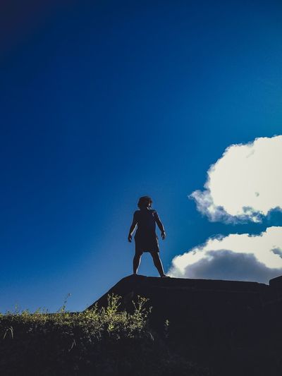 Low angle view of silhouette man running against sky