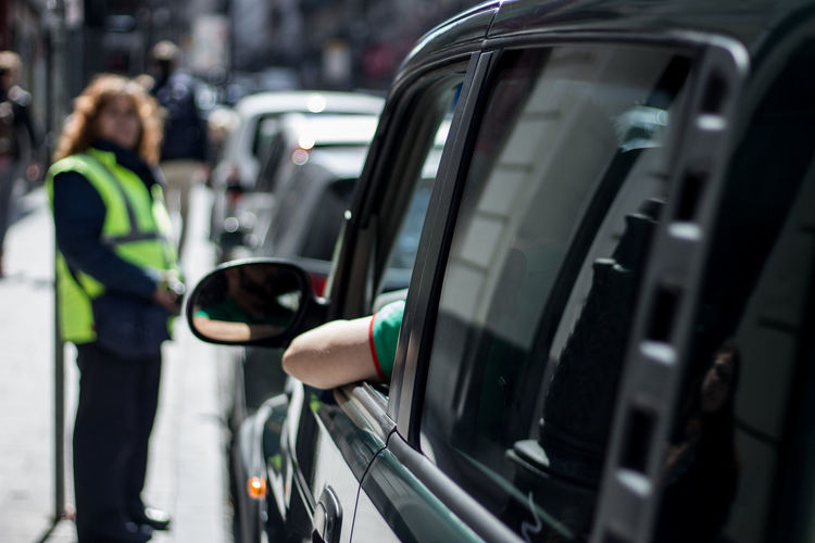 Cropped person in the vehicle against traffic cop