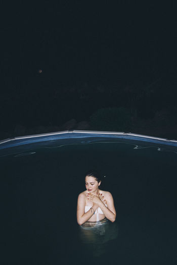 Young woman in swimming pool at night