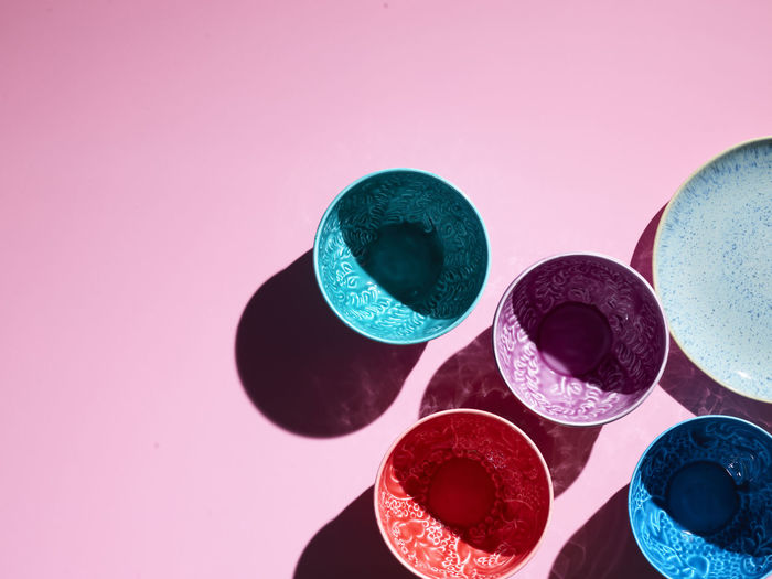 Studio shot of colorful bowls standing against pink background