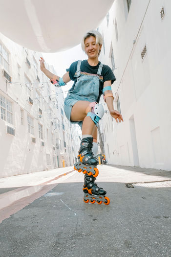 Holidays, sportive activities and hobby concept. young woman with roller skates riding outdoors.