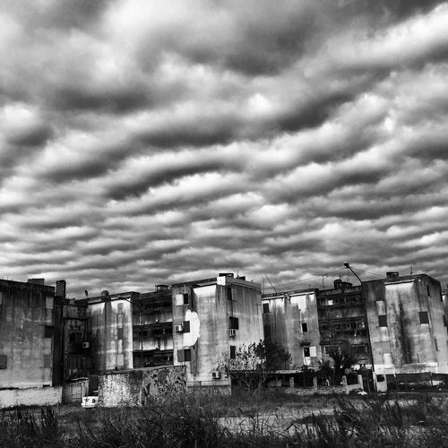 Old buildings in city against dramatic sky