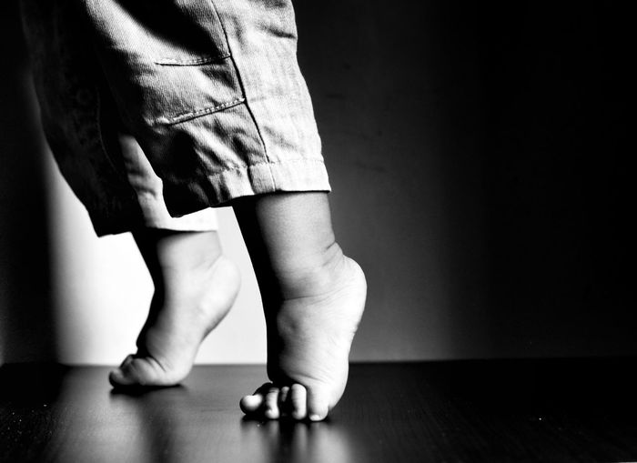 Low section of child tiptoeing at home