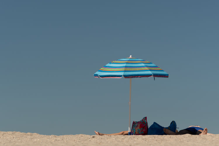 Umbrellas on beach against clear sky