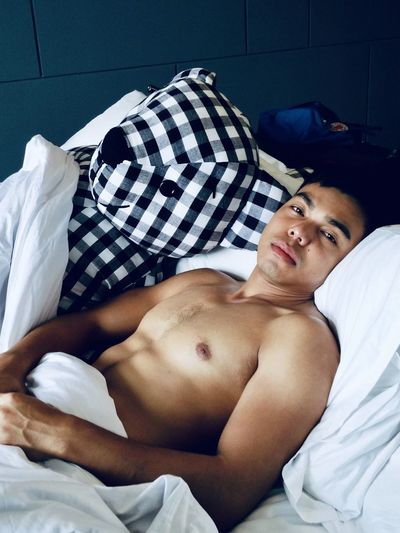 Young man lying down on bed