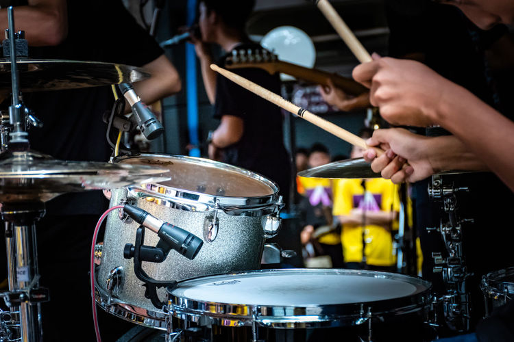 Cropped image of man playing drum at music concert
