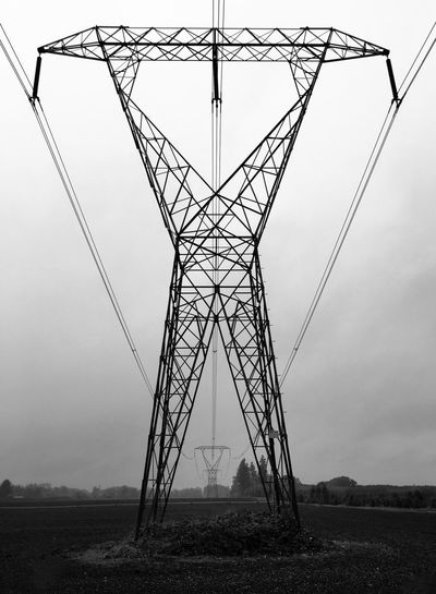 Low angle view of electricity pylon against sky