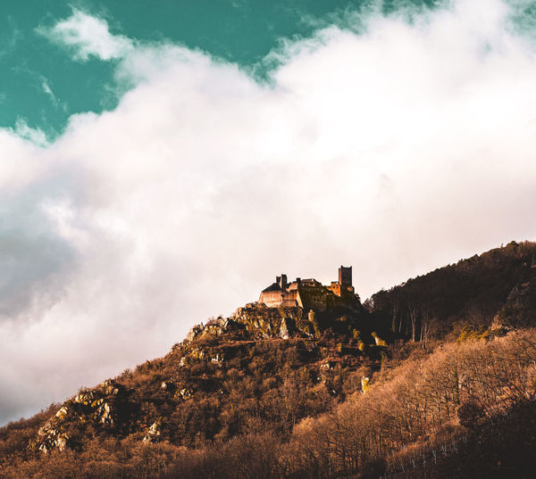 Low angle view of castle on mountain against sky
