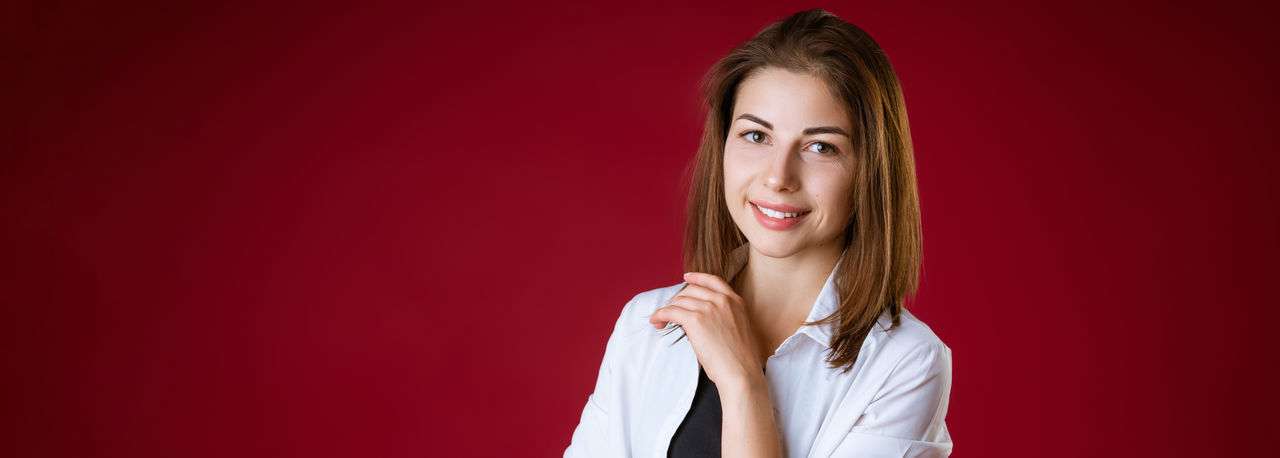 Portrait of a beautiful young woman over red background