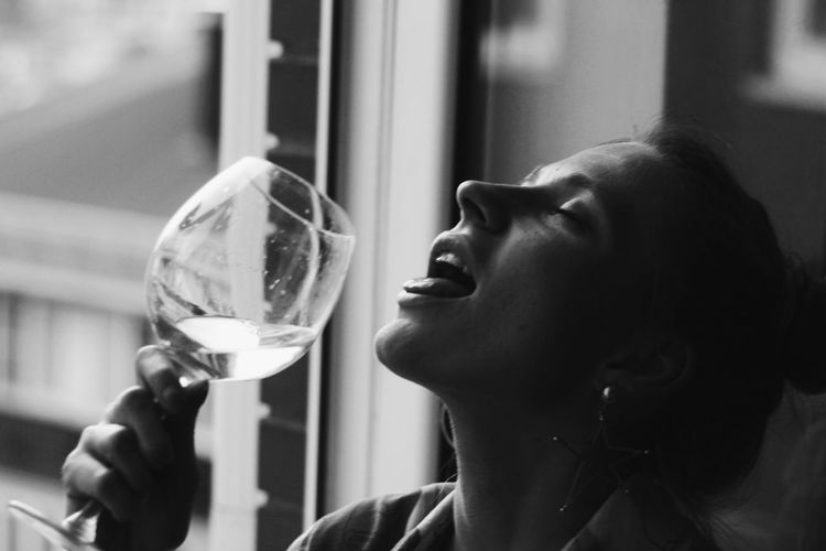 Close-up of woman drinking wine from glass