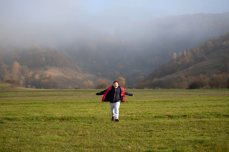 Full length of man standing on field during foggy weather