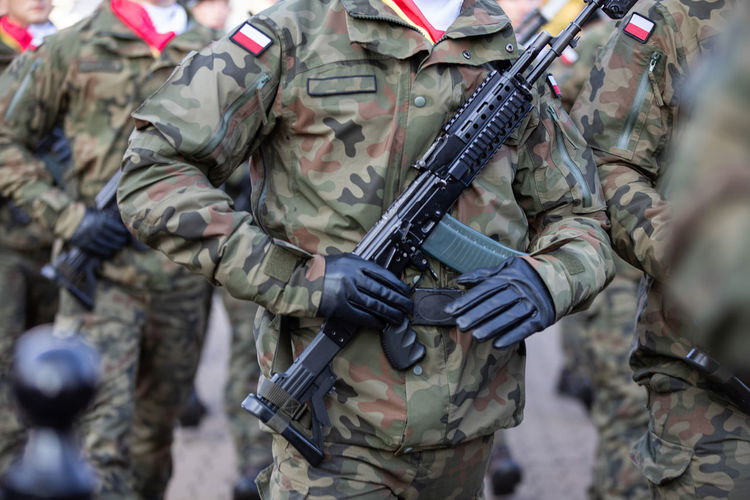 Armed polish soldiers with machine guns are marching.