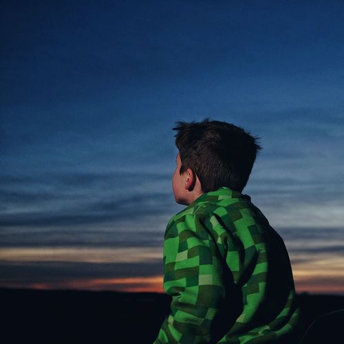 Boy looking at sky during sunset