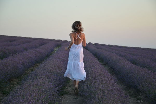 Rear view of woman standing on field against sky