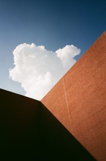 LOW ANGLE VIEW OF WALL AGAINST BUILDING AND SKY