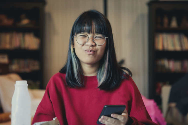 Happiness face of asian teenager eating snack in home living room