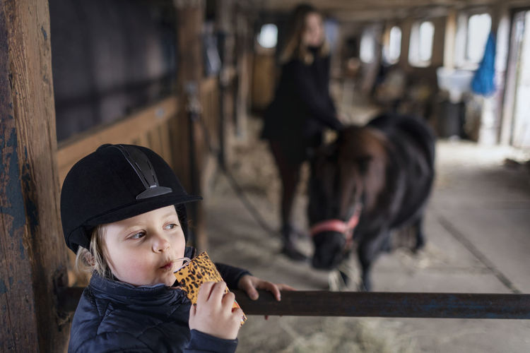 Girl drinking juice in stable