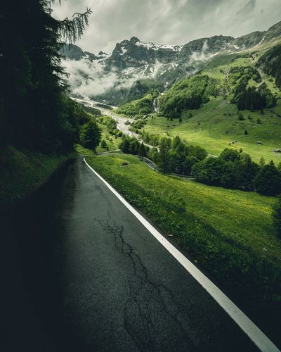 Road amidst green landscape against sky
