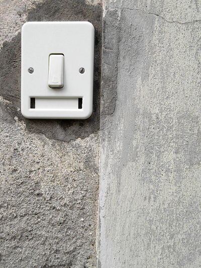 Close-up of doorbell on concrete wall