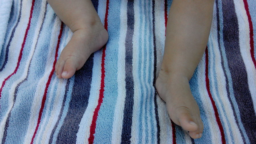 Low section of baby's feet on striped towel