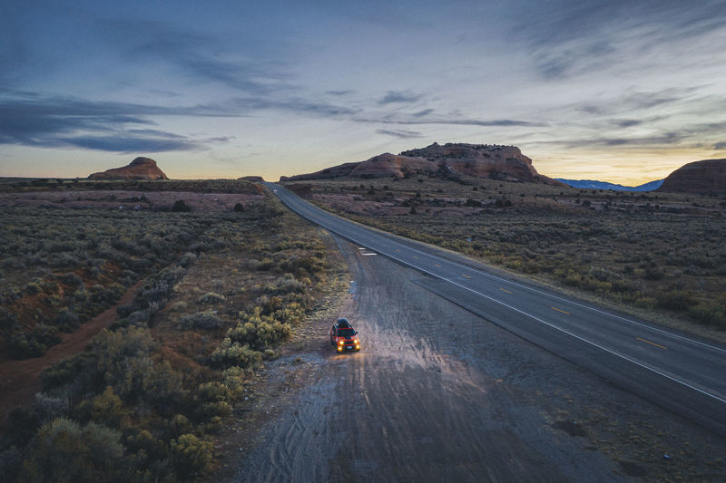 Lonely utah's road in the evening with a pulled over car