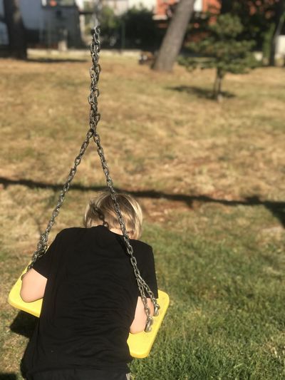 Rear view of woman on swing in playground