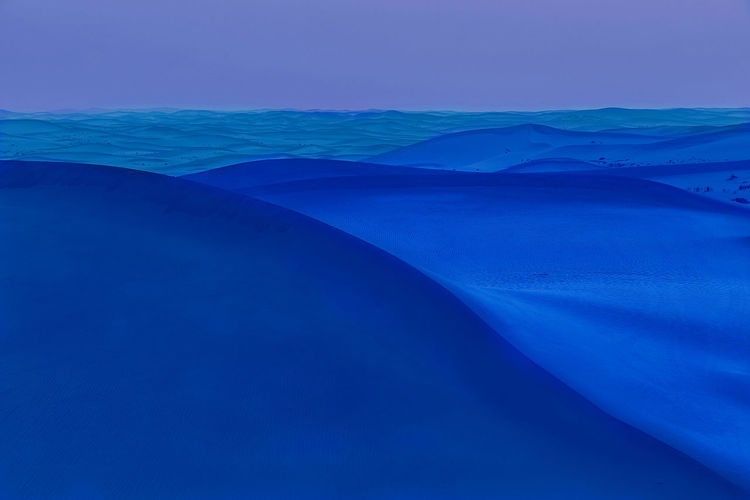 Digital composite image of sand dunes in desert at night