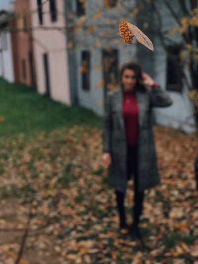 Woman standing by leaves during autumn
