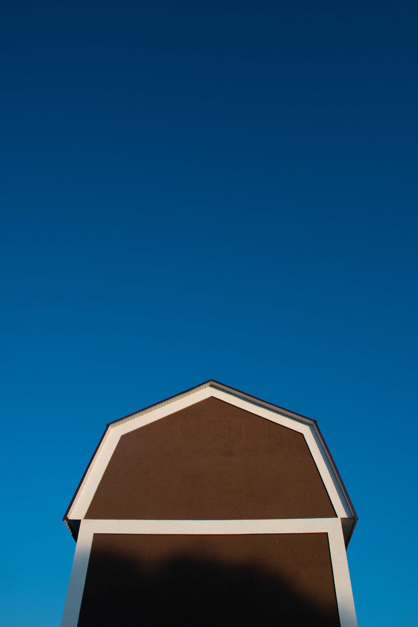 LOW ANGLE VIEW OF HOUSE AGAINST BLUE SKY