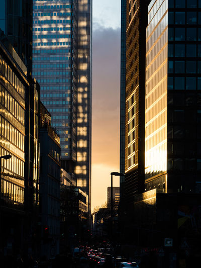 Modern buildings against sky at sunset