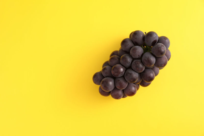 High angle view of blueberries against yellow background