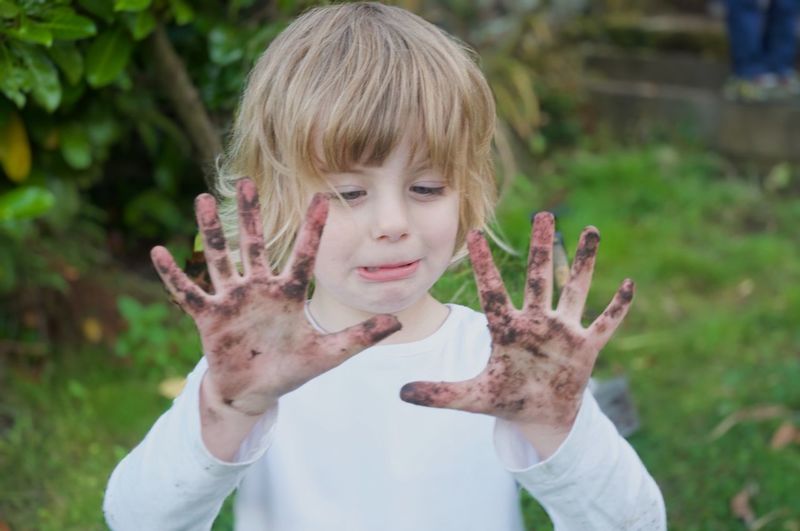 Portrait of happy girl with muddy hands