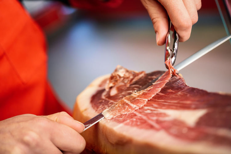 Midsection of woman cutting meat